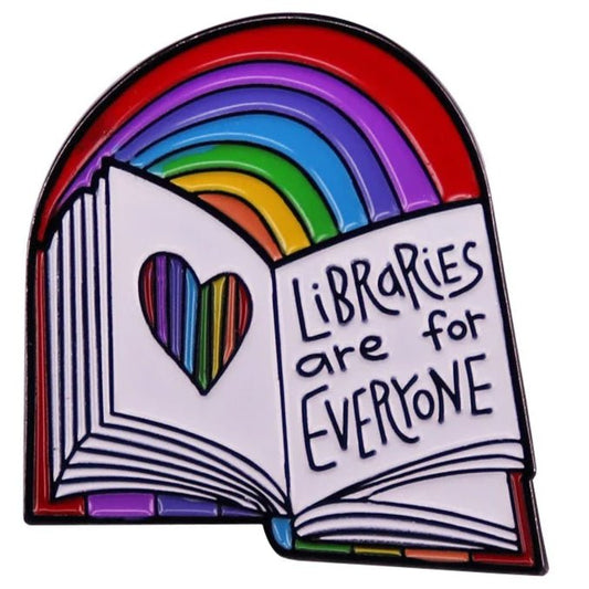 The "Libraries Are For Everyone" rainbow enamel pin features an open book with a rainbow heart cutout and colorful pages, celebrating inclusivity and diversity with a vibrant arching rainbow. Badge for librarian.