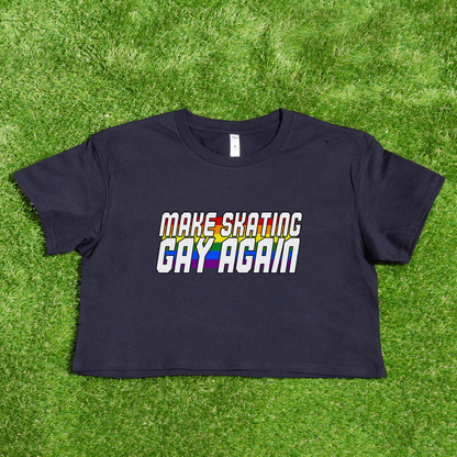 Navy blue crop tee from Gay Skate, featuring the vibrant rainbow pride text "MAKE SKATING GAY AGAIN" to celebrate queer skate culture, with a grass-like background.