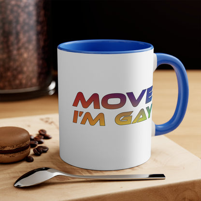 The MOVE I'M GAY accent mug by Printify features a clean white exterior with a striking blue handle and rim, and showcases bold, rainbow-colored "MOVE I'M GAY" text on its vibrant interior.