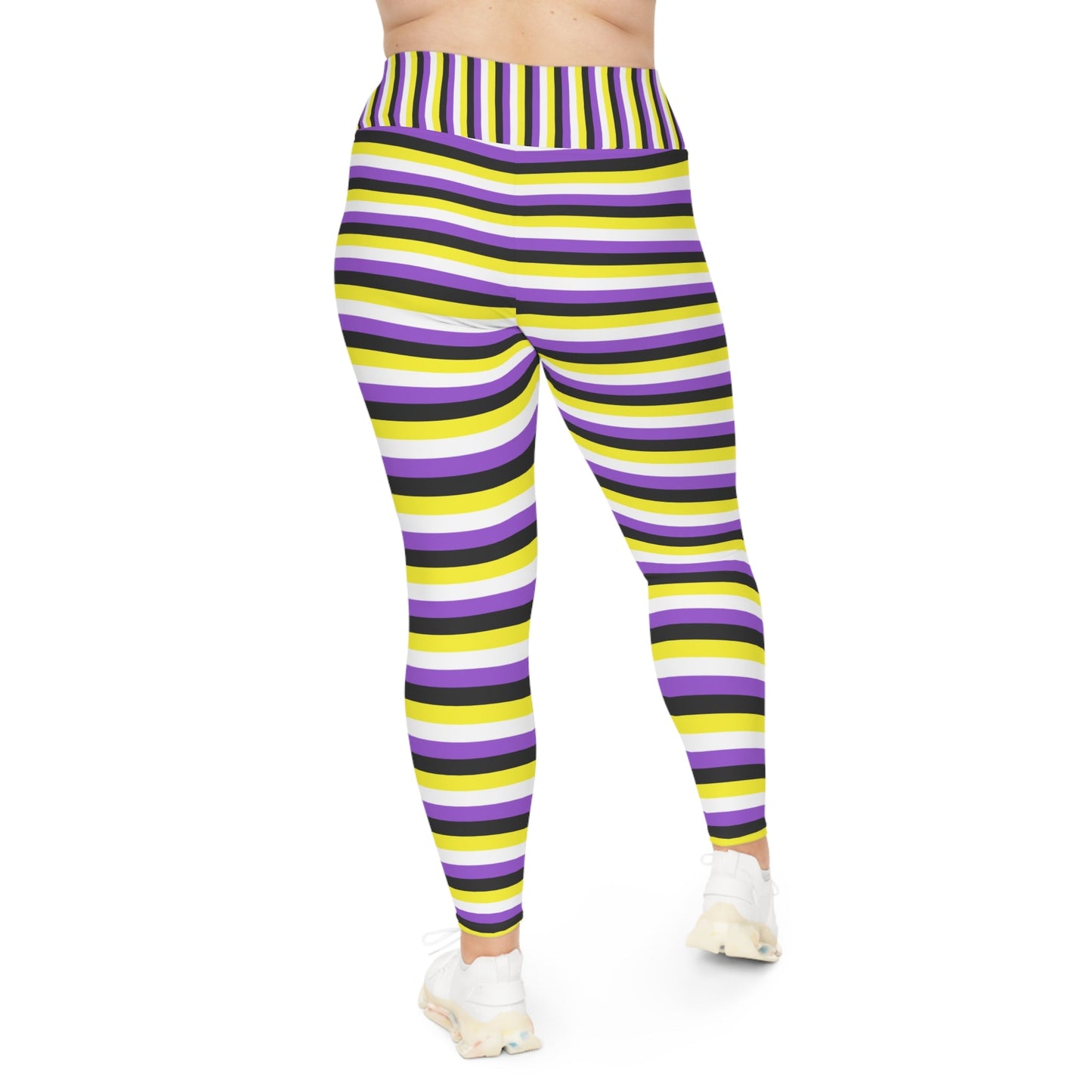 A person wearing Printify's Non-Binary Pride Flag Plus Size Leggings, sizes 2XL - 6XL, which feature high-waisted, colorful horizontal stripes in black, purple, yellow, and white. Made from 4-way stretch fabric for comfort and flexibility, they stand with their feet slightly apart. Only their legs and part of their torso are visible. They are also wearing white sneakers.