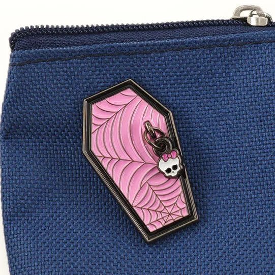 A coffin-shaped enamel pin with a pink spiderweb design and a small skull.