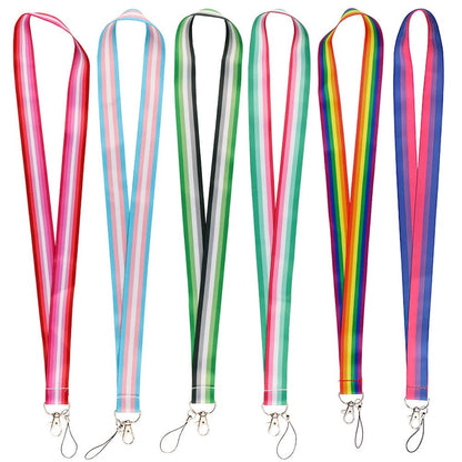 Six vibrant Pride Flag Lanyards from Gay Skate are displayed against a white background. Each practical neck strap showcases a distinctive design representing different pride flags: Rainbow, Trans, Non-Binary, Lesbian, Bisexual, Abrosexual/Abroromantic, and Aromantic. Every lanyard comes with a sturdy metal clip for securing keys or an ID.