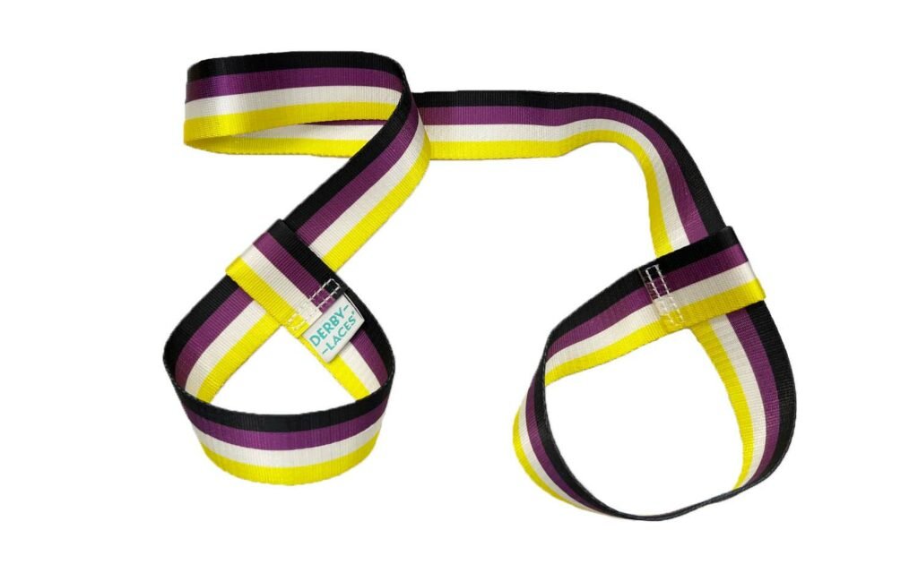 Three skate leashes are shown, each featuring unique striped color patterns: one with the rainbow flag, one with the Trans flag, and one with the Non-Binary flag. Each band has a looped design that can double as a yoga mat strap. These  skate nooses are branded under Gay Skate and named Pride Skate Leash – Gear strap.