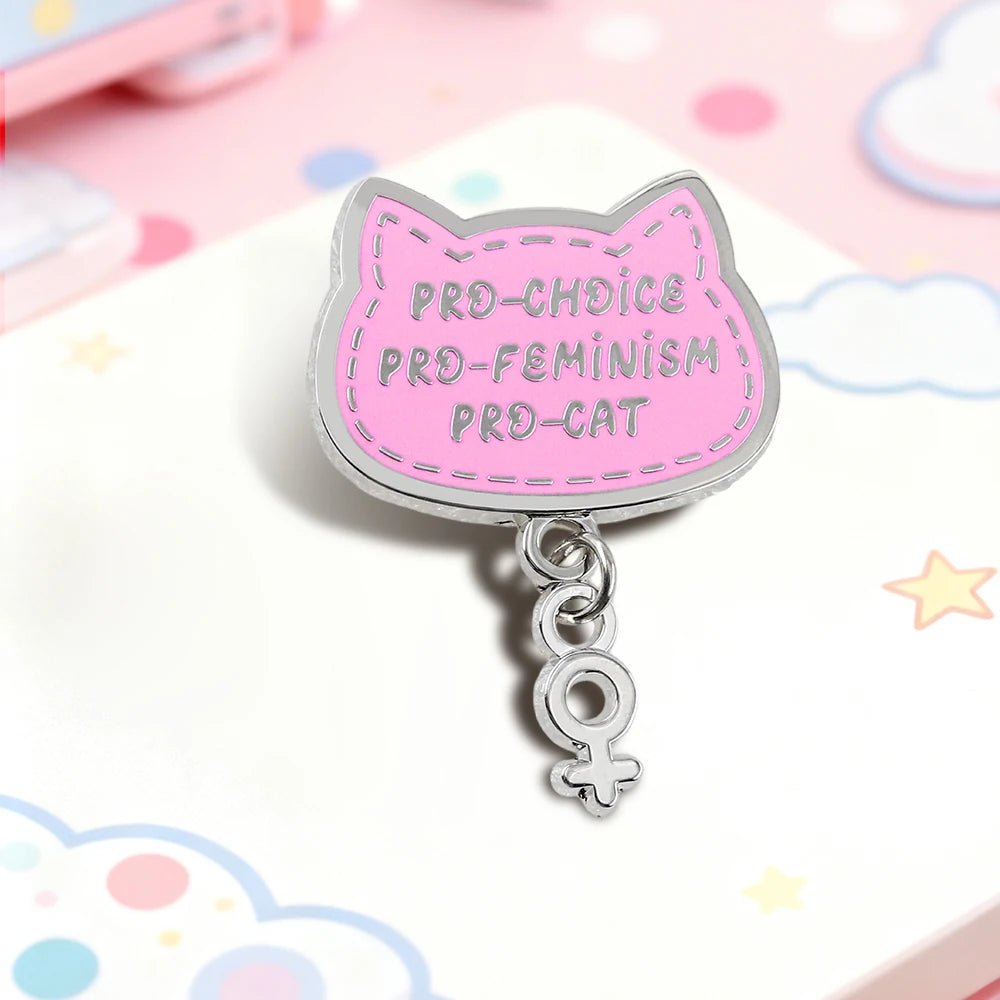Pink cat-shaped pin with 'Pro-Choice', 'Pro-Feminism', 'Pro-Cat' text and silver feminist charm