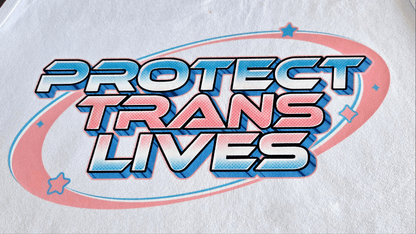 The "Protect Trans Lives - Local hand printed t-shirt" features bold, stylized text on a pink and blue oval with small stars. Celebrate diversity and make a powerful statement with this graphic tee, perfect for custom orders.