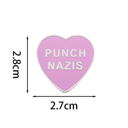 Heart-shaped pink and silver enamel pin with 'Punch Nazis' text 