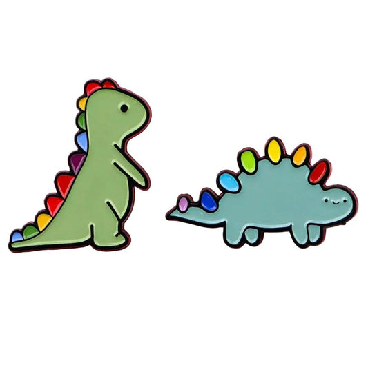 Two dinosaur-shaped pins with rainbow pride spikes. Subtle lgbt pride, neuro diversity autism pride