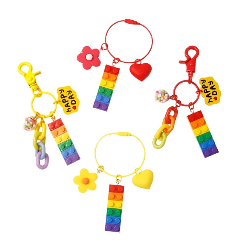 Displayed are four vibrant Rainbow Pride Keychain or Bag Charms from the brand Gay Skate. Each keychain features a rectangular block with rainbow stripes, adorned with charms like hearts, flowers, and beads, along with attached hooks. The blocks collectively spell "FLOVE." These keychains are perfect for expressing style and individuality while celebrating diversity and love in colorful hues.