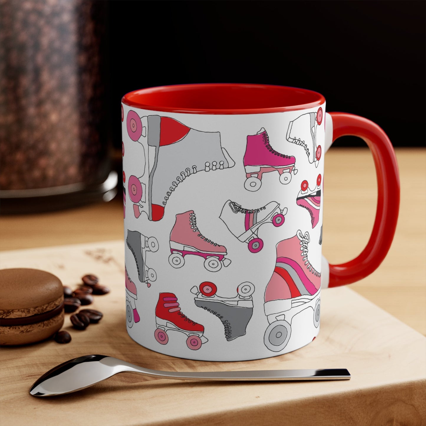 The Roller Skate cup from Printify is a white ceramic mug featuring a vibrant pattern of pink, red, and gray quad skates. The mug also highlights a red handle and interior that complement its playful design.