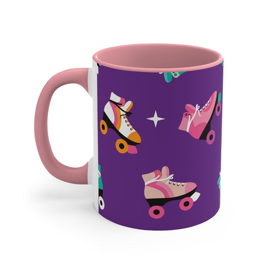 The Printify Roller Skates with a purple background - cute colourful accent mug features a white ceramic coffee mug with a pink handle and interior. Its design is adorned with various colorful roller skate illustrations against a vibrant purple background, showcasing skates in different styles and colors for a playful touch.