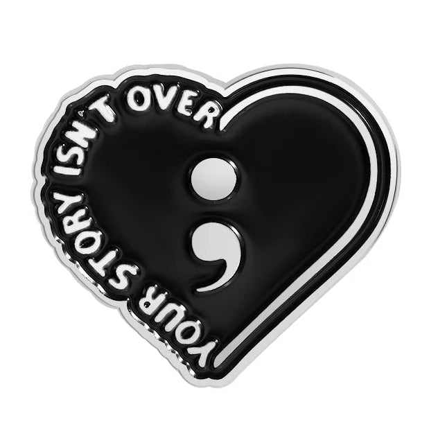 Your Story Isn't Over - Heart-shaped black enamel pin with semicolon symbol. Mental health awareness