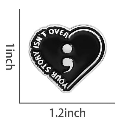 Your Story Isn't Over - Heart-shaped black enamel pin with semicolon symbol. Mental health awareness