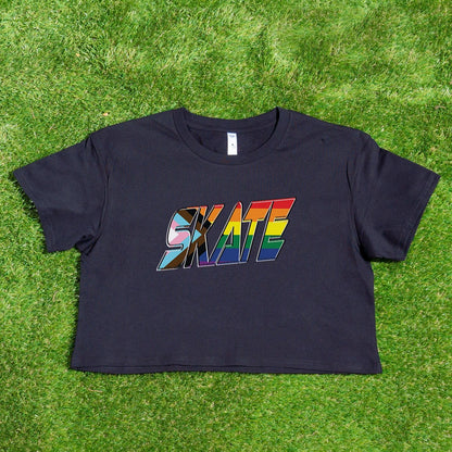 Introducing the "SKATE" progress pride rainbow flag locally printed crop tee by Gay Skate – a stunning black short-sleeve cropped t-shirt that proudly displays "SKATE" in large, bold letters across the chest. The vibrant font features a colorful, diagonal rainbow gradient, capturing the spirit of queer skatewear and celebrating individuality and pride.