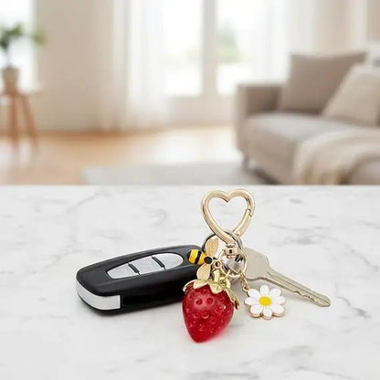 Gold Keychain with heart-shaped clasp, red strawberry, diamante bee, and flower charm