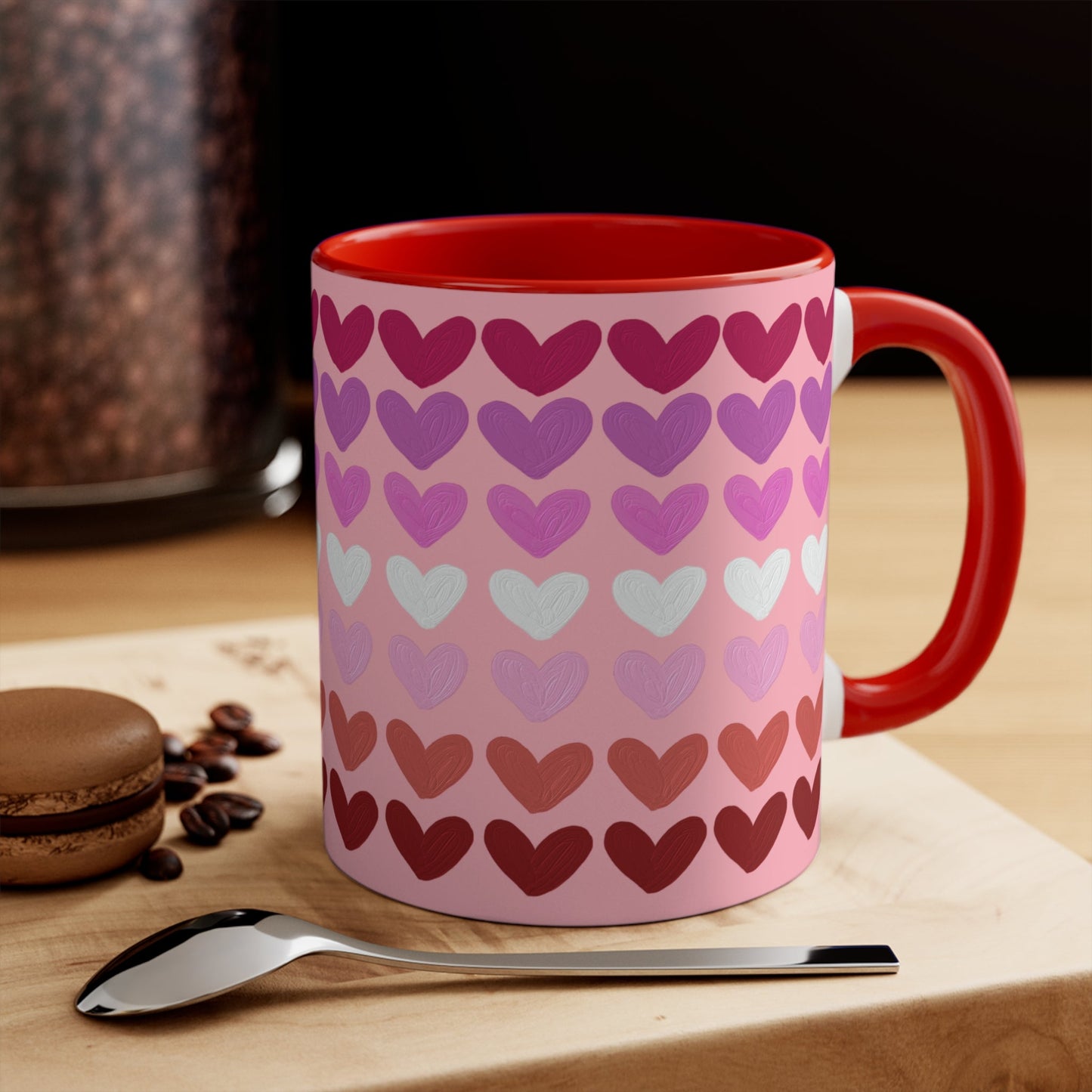 The "Subtle Lesbian Pride Flag - love hearts - colourful accent mug" by Printify is a white ceramic mug with a vibrant interior and red handle, adorned with heart patterns in various shades of pink, purple, and red. The hearts are arranged in horizontal rows, gradually transitioning from lighter shades at the top to darker ones at the bottom.