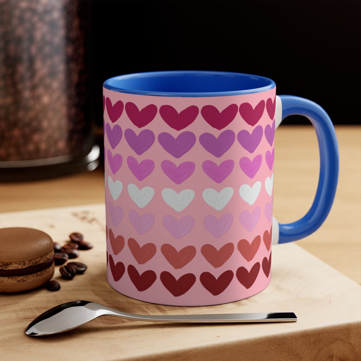 The "Subtle Lesbian Pride Flag - love hearts - colourful accent mug" by Printify is a white ceramic mug with a vibrant interior and red handle, adorned with heart patterns in various shades of pink, purple, and red. The hearts are arranged in horizontal rows, gradually transitioning from lighter shades at the top to darker ones at the bottom.