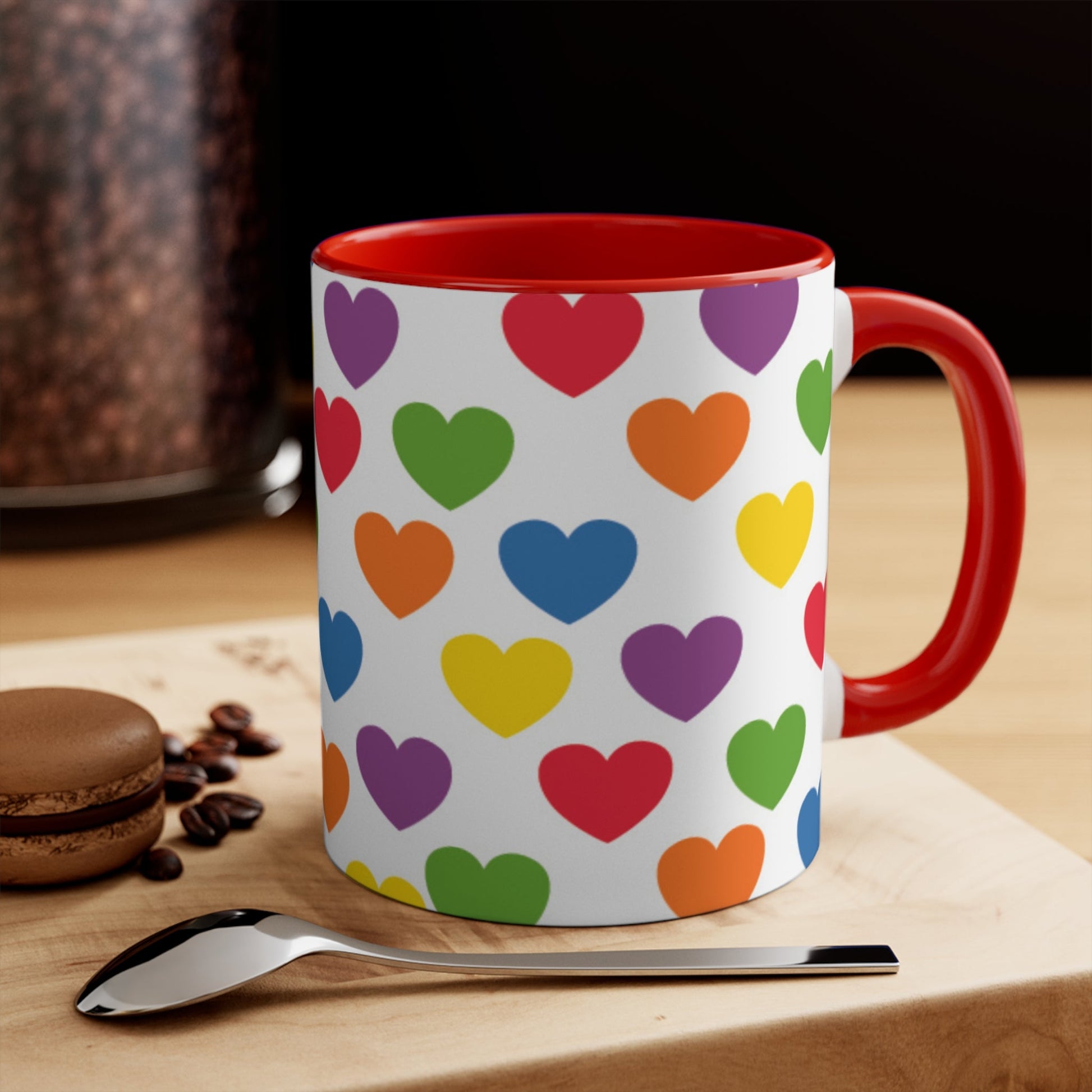 The Subtle Rainbow pride love hearts colourful accent mug by Printify is a white ceramic mug featuring a red handle and a colorful interior, adorned with heart patterns in the vibrant hues of the Rainbow pride flag: red, blue, green, yellow, orange, and purple.