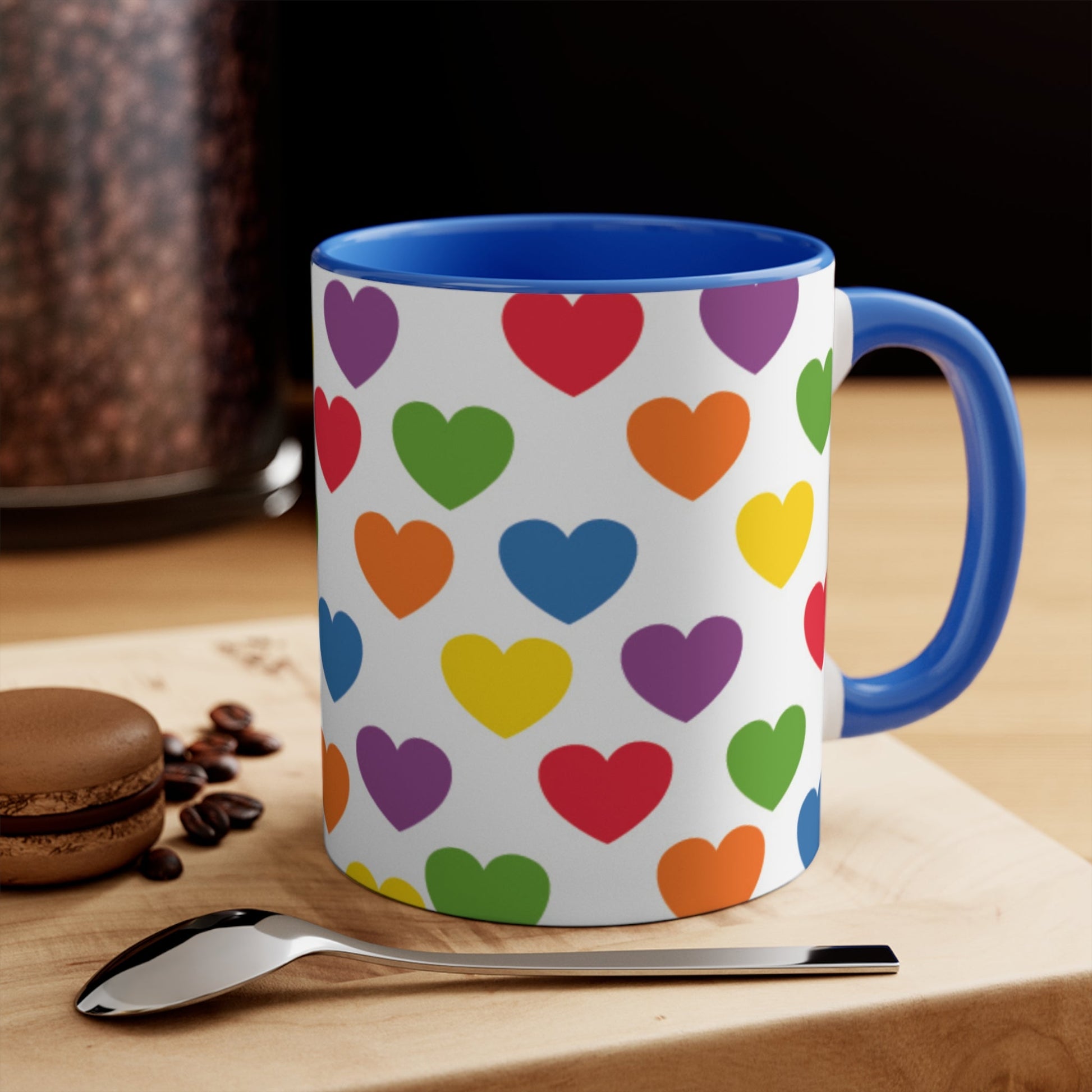 The Subtle Rainbow pride love hearts colourful accent mug by Printify is a white ceramic mug featuring a red handle and a colorful interior, adorned with heart patterns in the vibrant hues of the Rainbow pride flag: red, blue, green, yellow, orange, and purple.