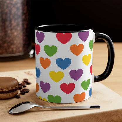 The Subtle Rainbow pride love hearts colourful accent mug by Printify is a white ceramic mug featuring a red handle and a colorful interior, adorned with heart patterns in the vibrant hues of the Rainbow pride flag: red, blue, green, yellow, orange, and purple.