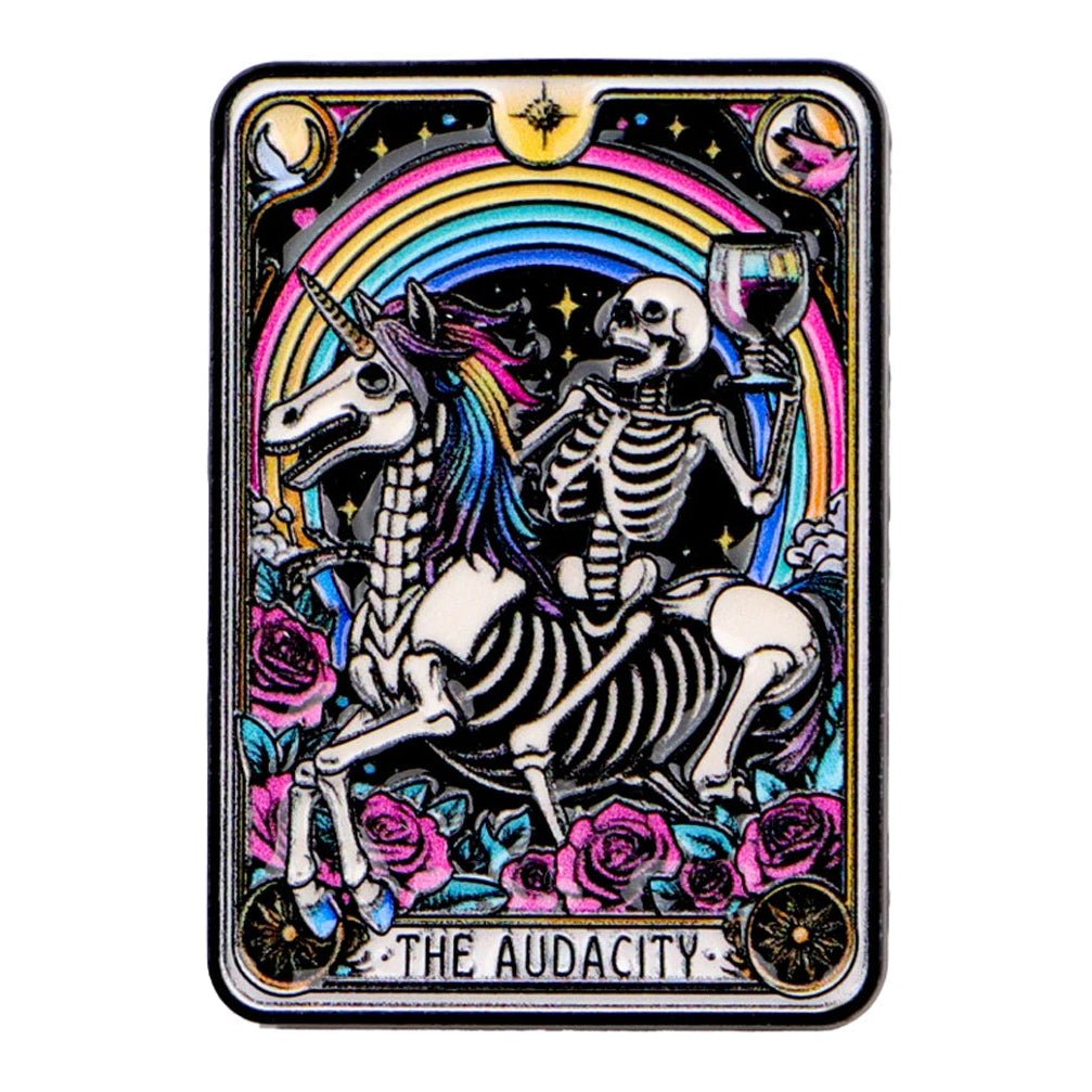 Tarot Card enamel pin featuring a skeleton on a unicorn with a rainbow and roses, labeled 'The Audacity'.