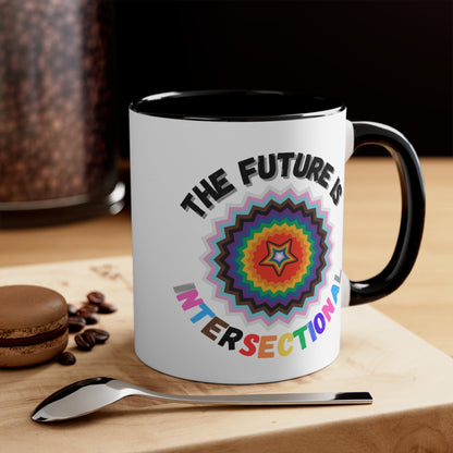 The Future Is Intersectional - original design - colourful accent mug by Printify is a white mug with a blue handle and interior, featuring an original star-shaped pattern in vibrant colors at the center. The text "THE FUTURE IS" appears above the pattern, and "INTERSECTIONAL" is displayed below in rainbow-colored letters, creating an eye-catching color contrast.