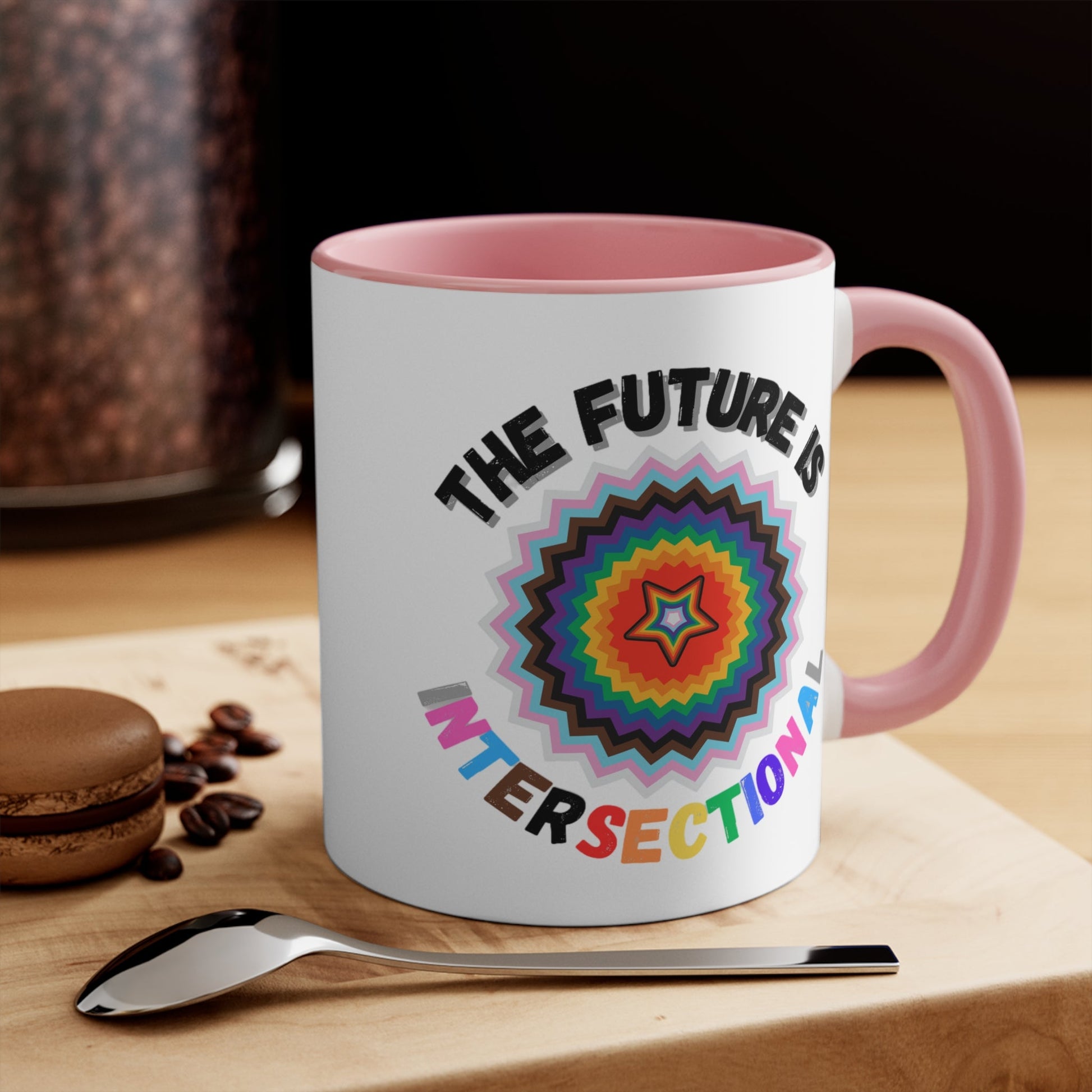 The Future Is Intersectional - original design - colourful accent mug by Printify is a white mug with a blue handle and interior, featuring an original star-shaped pattern in vibrant colors at the center. The text "THE FUTURE IS" appears above the pattern, and "INTERSECTIONAL" is displayed below in rainbow-colored letters, creating an eye-catching color contrast.