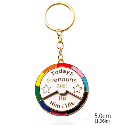 Keychain with rainbow design and text 'Today's pronouns are: He Him / His' 