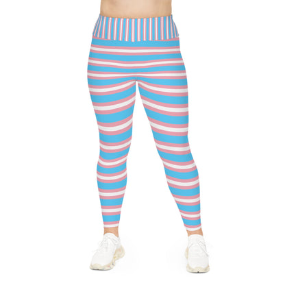 A person is modeling vibrant Trans Pride Plus Size Leggings (available in sizes 2XL - 6XL), featuring horizontal stripes in blue, pink, and white to represent transgender pride. The leggings are coordinated with white sneakers against a plain white background. The image focuses solely on the lower body, excluding the upper body and face.