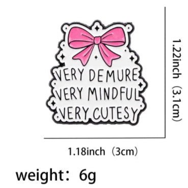 The "Very Demure Very Mindful Very Cutesy" enamel badge features a pink bow on a white background. It measures 1.22 x 1.18 inches and weighs 6 grams.