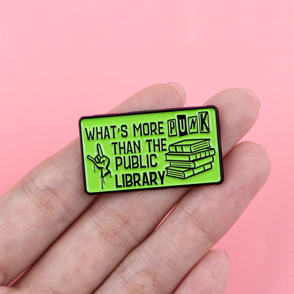 Green enamel pin with text WHAT'S MORE PUNK THAN THE PUBLIC LIBRARY and graphic 