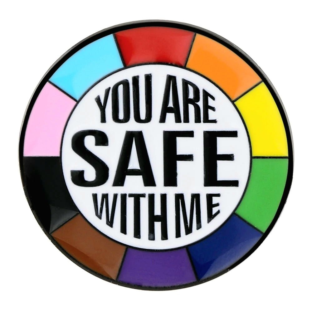 The "You Are Safe With Me - ally enamel pin" features a round design with a rainbow-colored border, black text in the center reading "YOU ARE SAFE WITH ME," and a white background.